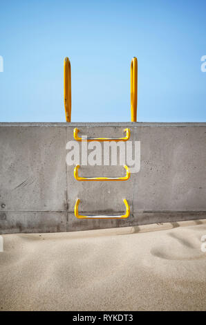 Scaletta di acciaio annegata in un muro di cemento, quadro concettuale. Foto Stock