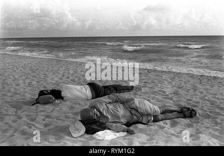 Sonno Dormire Miami South Beach, Florida. Stati Uniti d'America. 1999 senzatetto uomini sonno agitato sulla spiaggia degli anni novanta siamo HOMER SYKES Foto Stock