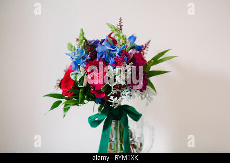 Un vibrante matrimonio colorati mazzo di fiori su uno sfondo semplice Foto Stock