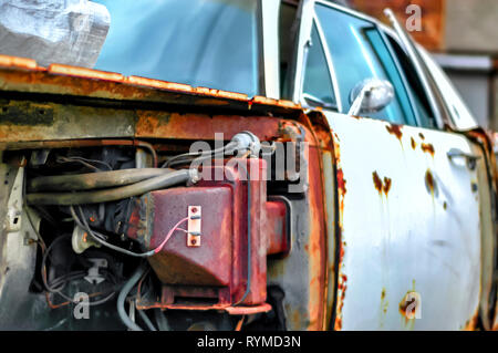 Chiudere l immagine di un abbandonato Lincoln Continental auto adiacente ad una fabbrica abbandonata edificio in Pontiac, Michigan, Stati Uniti d'America. Foto Stock