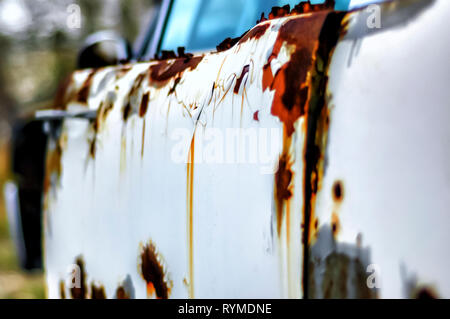 Chiudere l immagine della ruggine esterna di una Lincoln Continental auto adiacente ad una fabbrica abbandonata edificio in Pontiac, Michigan, Stati Uniti d'America. Foto Stock