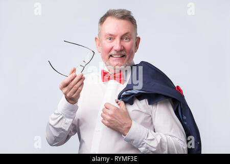 Senior uomo caucasico indossare tuta blu sorridente calorosamente e fiducioso. Foto Stock