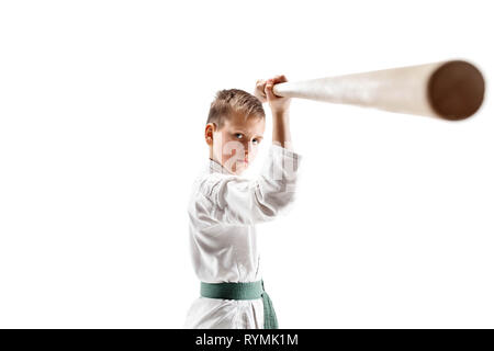 Teen boy combattimenti con la spada in legno a Aikido la formazione nella scuola di arti marziali. Uno stile di vita sano e sport concetto. Fightrer in kimono bianco su sfondo bianco. Il Karate uomo in uniforme. Foto Stock