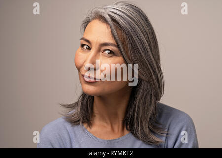 Un mongolo Silver-Haired donna guarda pensieroso nel telaio. Foto Stock