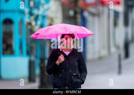 Martedì 12 marzo 2019 nell'immagine: una donna si nasconde sotto il suo ombrello in Carmarthen, Wales UK avanti di tempesta Gareth Re: venti forti hanno portato travel Foto Stock