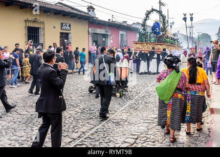 Antigua Guatemala - 18 Febbraio 2018: musicisti & Maya donne seguire dietro la Quaresima processione in città coloniale con il famoso alle celebrazioni della Settimana Santa Foto Stock