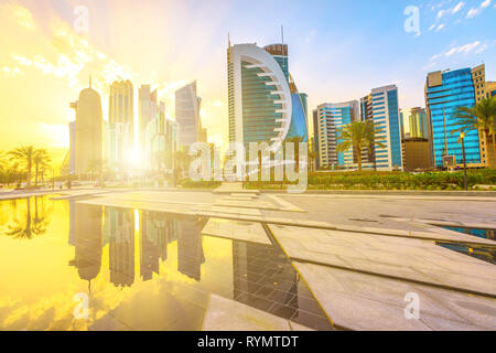 Scenic Doha West Bay alta sorge al tramonto che riflette la luce in acqua del parco del centro. I moderni grattacieli di skyline di Doha in Qatar nel Medio Oriente Foto Stock