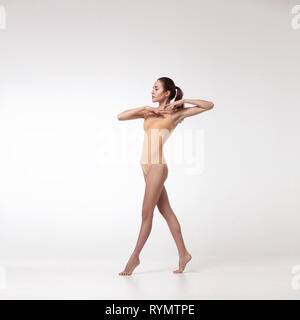 Giovane bellissima ballerina in costume da bagno di colore beige Foto Stock