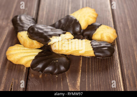 Sacco di tutta una metà del pigro cookie con cioccolato sulla catasta di legno marrone Foto Stock