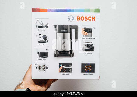 Parigi, Francia - Luglio 12, 2018: Man mano che tiene in acciaio inox Bosch TWK7203 bollitore scatola di cartone con funzioni multiple Foto Stock