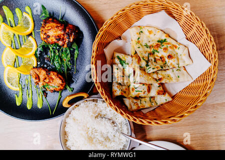 Pane Naan, pollo tandoori e riso come cibo indiano cucina in un ristorante di Lubiana in Slovenia. Foto Stock