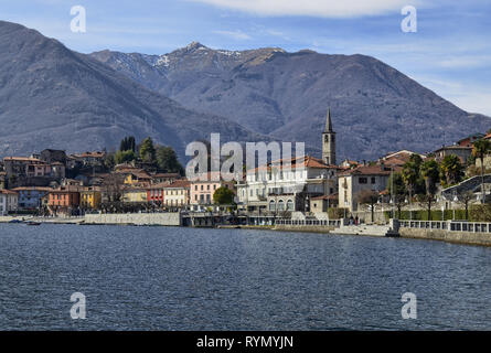 Mergozzo, Piemonte, Italia. Marzo 2019. Vista del paese che si affaccia sulle calme acque del lago. Le facciate con la loro calorosa e colori luminosi stan Foto Stock