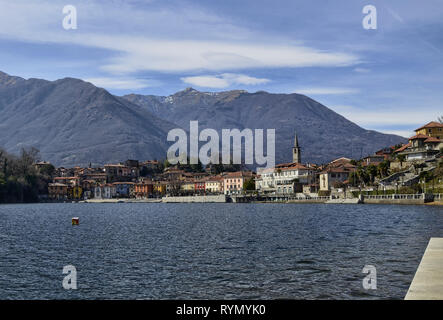 Mergozzo, Piemonte, Italia. Marzo 2019. Vista del paese che si affaccia sulle calme acque del lago. Le facciate con la loro calorosa e colori luminosi stan Foto Stock