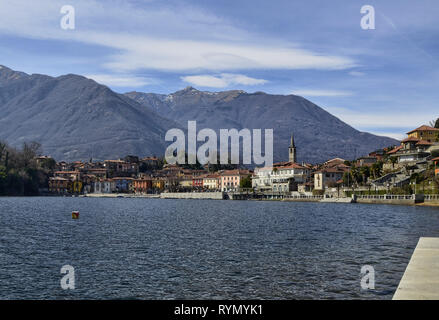 Mergozzo, Piemonte, Italia. Marzo 2019. Vista del paese che si affaccia sulle calme acque del lago. Le facciate con la loro calorosa e colori luminosi stan Foto Stock