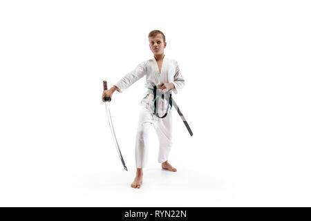 Teen boy combattimenti alla formazione di Aikido nella scuola di arti marziali. Uno stile di vita sano e sport concetto. Fightrer in kimono bianco su sfondo bianco. Il Karate uomo con faccia concentrato in uniforme. Foto Stock