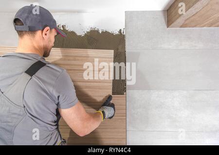 Caucasian Piastrelle Ceramiche Installer sul lavoro. Bagno rimodellamento concetto. Foto Stock