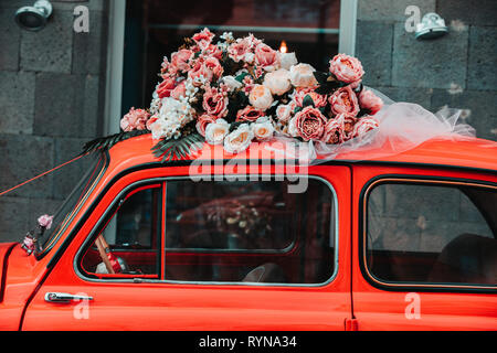 Vecchia auto rossa con fiori Foto Stock