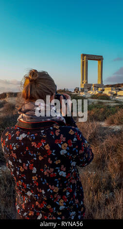 Giovane turista femminile donna di scattare una foto della Portara di Naxos, Tempio di Apollo di ingresso, Naxos, isole Cycaldic, Grecia Foto Stock