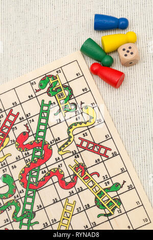 Primo piano di piccoli Snakes e Ladders gioco / gioco da tavolo per scalare scala di carriera, salire a casa scala, arrampicata sociale, lotta, alti e bassi Foto Stock