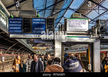 Pendolari ad una trafficata stazione della metropolitana di Earls Court sul distretto e Piccadilly Lines, Londra, Regno Unito Foto Stock