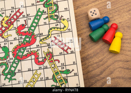 Primo piano di piccoli Snakes e Ladders gioco / gioco da tavolo per scalare scala di carriera, salire a casa scala, arrampicata sociale, lotta, alti e bassi Foto Stock