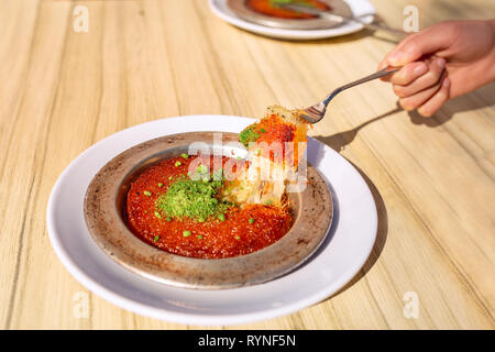 Dolce turco kunefe, kunafa, kadayif con polvere di pistacchi e formaggio servito caldo, molto dolce. Bagno turco dessert tradizionale Foto Stock