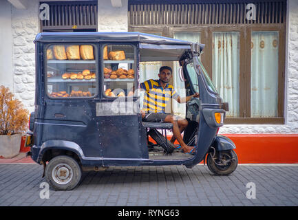 Consegna pane man in black tuktuk nella parte vecchia di Galle . Galle, Sri Lanka Foto Stock