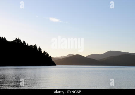 Luce della Sera a Double Bay Cove nel Marlborough Sounds della Nuova Zelanda. Il Cove è spento di Queen Charlotte Sound, il principale canale di spedizione. Foto Stock