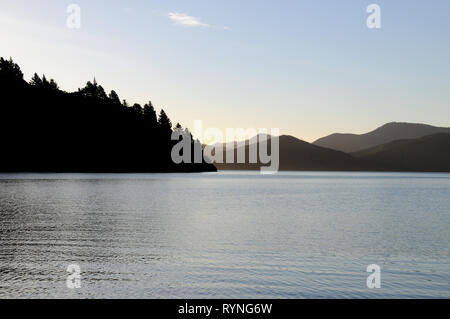 Luce della Sera a Double Bay Cove nel Marlborough Sounds della Nuova Zelanda. Il Cove è spento di Queen Charlotte Sound, il principale canale di spedizione. Foto Stock