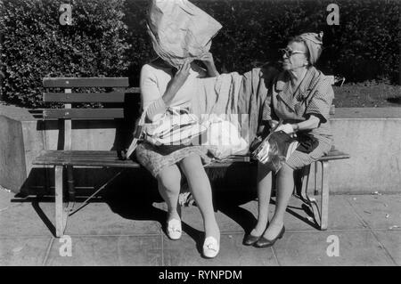 Due donne più anziane che chiacchierano in un parco del centro, una ha realizzato un cofano da un sacchetto di carta marrone per proteggersi dal sole. San Francisco, California. Persone degli anni '1971 1970, USA HOMER SYKES Foto Stock