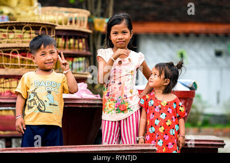 Ritratti di tre bellissimi bambini laotiani che sorridere e divertirsi in un tempio a Luang Prabang, Laos. Foto Stock