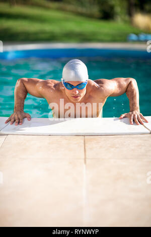 Piscina muscolare uomo con gli occhiali di protezione e il tappo in piscina Foto Stock