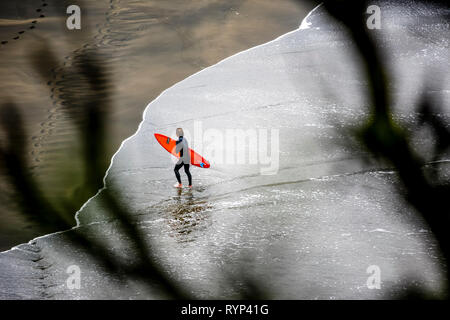 Surfer permanente al Piha Beach, Nuova Zelanda Foto Stock