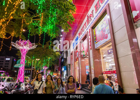 La città di Ho Chi Minh, Vietnam - 17 Febbraio 2019: accesa Nguyen Hue Street dal Cafe Appartamento's Bookstore di notte con la gente di passaggio. Foto Stock