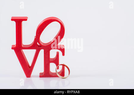 Red lettere di amore su sfondo bianco sulla sinistra con anello Foto Stock