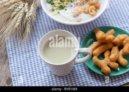 Breakfase pasto. Congee o riso porridge di carne macinata di maiale, uovo sodo con latte di soia e il cinese fritte doppio bastone di pasta Foto Stock