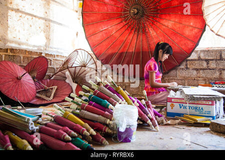 Una donna rende la carta ombrelloni a un ombrello workshop in Pindaya, Myanmar Foto Stock