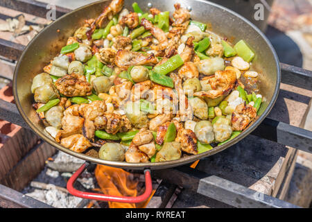 Processo di cottura di una tradizionale paella valenciana in una padella  per paella con fuoco a gas