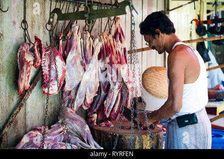 Un macellaio vendita di carni in 26th street market, Yangon, Myanmar Foto Stock