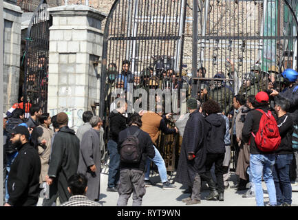 Srinagar Kashmir. Il 15 marzo, 2019. Manifestanti del Kashmir e adoratori cercando di aprire il cancello principale della Grande Moschea Jamia come la polizia indiana guardare ,durante una manifestazione di protesta contro la .National Investigation Agency (NIA) che chiamò separatista senior e leader religiosi Mirwaiz Umer Farooq a Delhi finora due volte .e denunciare il massacro di 49 persone in due Nuova Zelanda moschee dicendo la brutalità ha dimostrato che non vi è posto il terrorismo non può arrivare.©Sofi Suhail/Alamy Live News Foto Stock