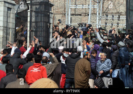 Srinagar Kashmir. Il 15 marzo, 2019. Manifestanti del Kashmir e adoratori gridare slogan nel cancello principale della Grande Moschea Jamia come la polizia indiana guardare ,durante una manifestazione di protesta contro la .National Investigation Agency (NIA) che chiamò separatista senior e leader religiosi Mirwaiz Umer Farooq a Delhi finora due volte .e denunciare il massacro di 49 persone in due Nuova Zelanda moschee dicendo la brutalità ha dimostrato che non vi è posto il terrorismo non può arrivare.©Sofi Suhail/Alamy Live News Foto Stock