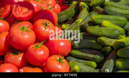 Pomodori e cetrioli fianco a fianco sul display cestello nella bazarre Foto Stock