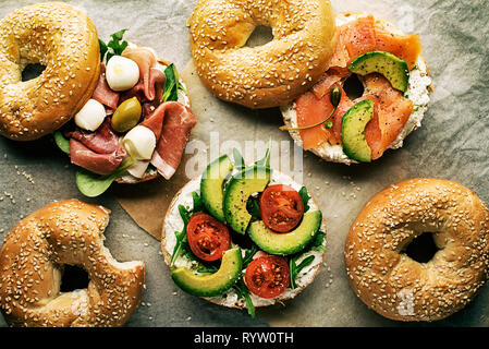 Bagel sandwich con avocado, salmone, prosciutto e formaggio mozzareela. Cibo sano. Foto Stock