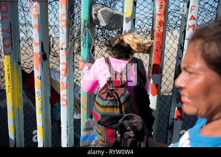 Le famiglie sono visti scivolare attraverso gli Stati Uniti - Messico - recinzione di confine in sforzi per chiedere asilo negli Stati Uniti. Nel febbraio 2019, circa 76.000 sono fuggiti dal sud del confine con gli Stati Uniti al fine di trovare una migliore live. Foto Stock
