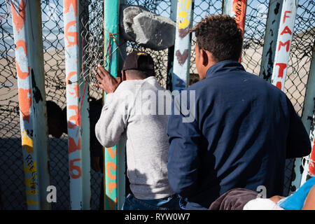 Le famiglie sono visti scivolare attraverso gli Stati Uniti - Messico - recinzione di confine in sforzi per chiedere asilo negli Stati Uniti. Nel febbraio 2019, circa 76.000 sono fuggiti dal sud del confine con gli Stati Uniti al fine di trovare una migliore live. Foto Stock