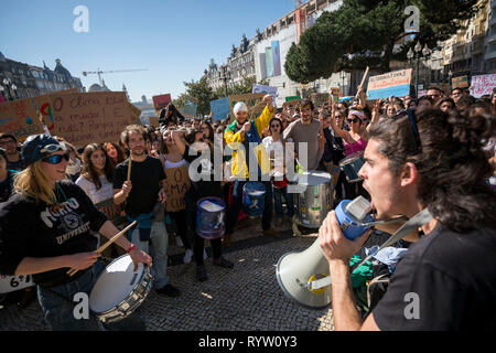 I manifestanti visto suonando la batteria e gridando slogan per un megafono durante la dimostrazione. Stadio di studenti di una protesta contro il mondo politiche sul clima di fronte a Porto Municipio in Portogallo. Foto Stock