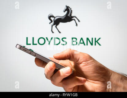 Un uomo utilizzando Lloyds Bank online banking sul suo telefono cellulare Foto Stock