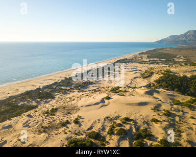 Drone vista aerea della grande duna di sabbia montagna alle spalle della costa del mare spiaggia di Patara, Turchia Foto Stock