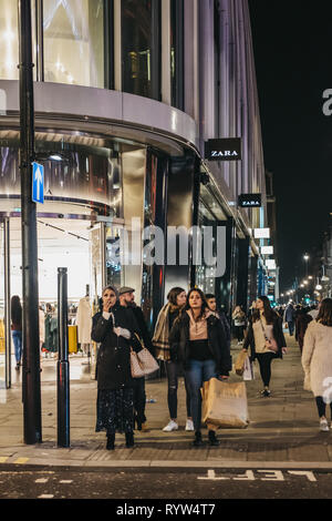 London, Regno Unito - 9 Marzo 2019: la gente a piedi nella parte anteriore del negozio di Zara su Oxford Street, Londra, la sera. Oxford street è uno dei più famosi sho Foto Stock