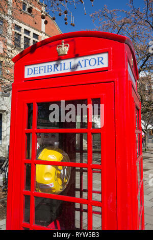 Un convertito Sir Giles Gilbert Scott K6 casella telefono ora utilizzato per memorizzare un defibrillatore in Londra, Regno Unito Foto Stock